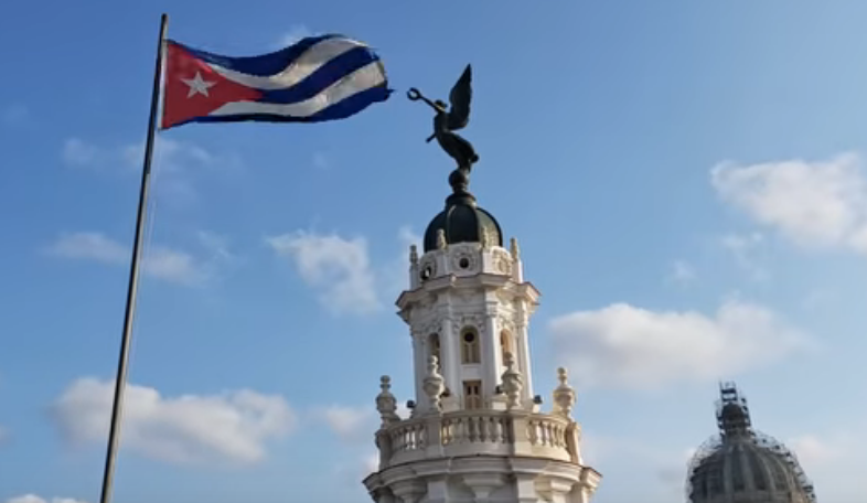 Cycling tours and bike rental in Cuba - A Cuban flag in Havana, ¨Giraldilla¨ and ¨Capitolio¨